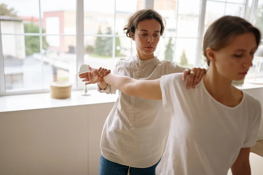 A physio guiding a shoulder exercise