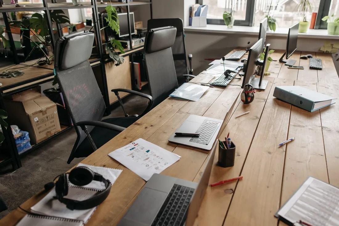 Desks in an open-plan office, cleaned and ready for the morning