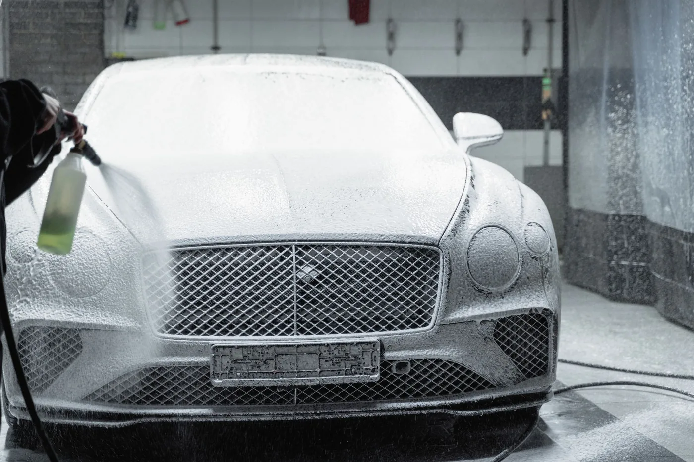 A car covered in snow foam before the contact wash