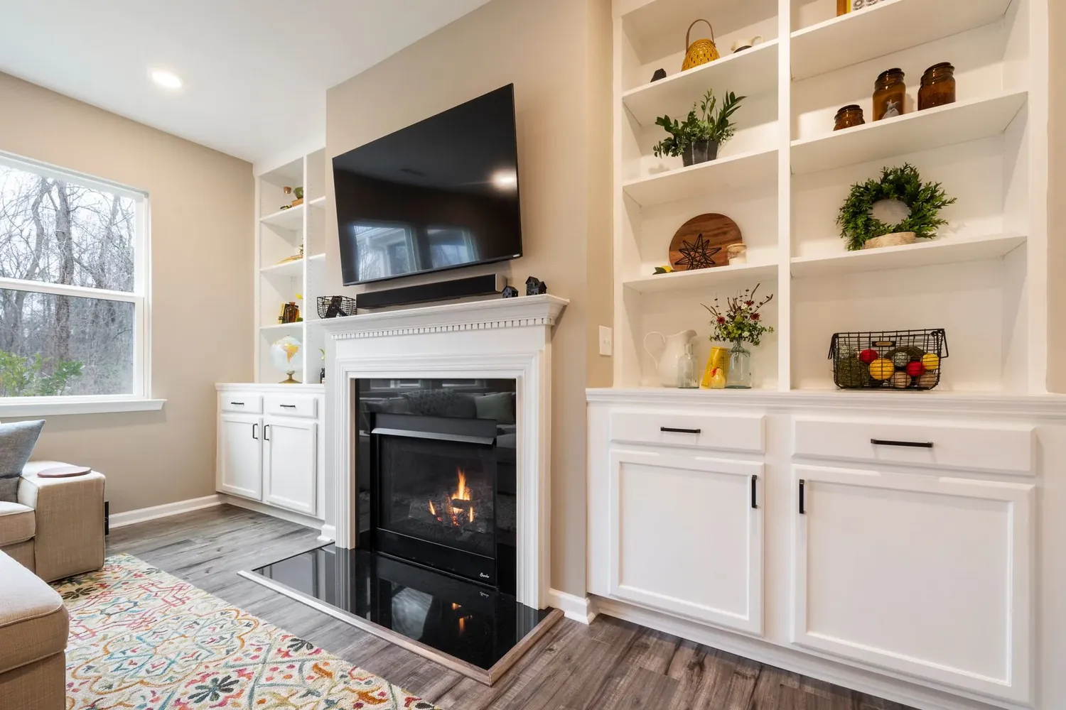 Painted alcove units with shelving and cupboards either side of a fireplace
