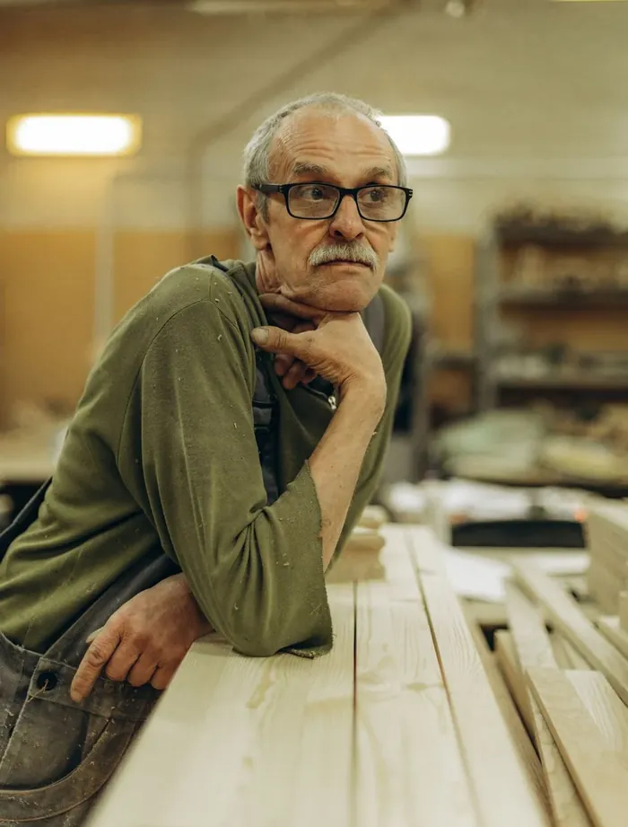 Alasdair Grant, master joiner, leaning on his bench