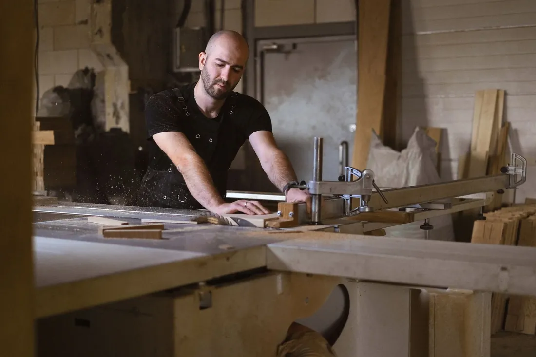 A joiner cutting boards at the saw bench in a timber workshop