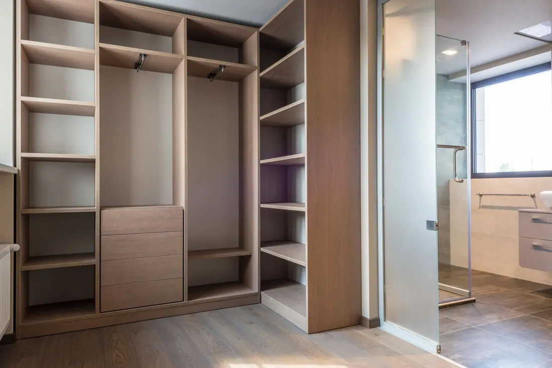 An open wardrobe with oak shelves and drawers