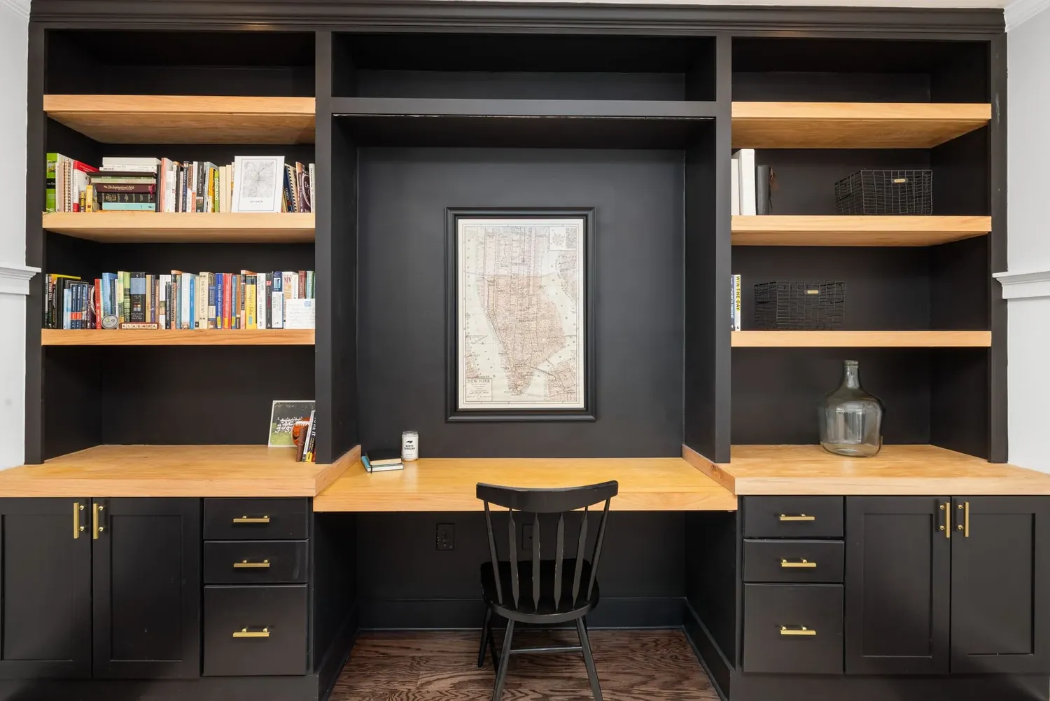 A painted built in study wall with bookshelves and a desk
