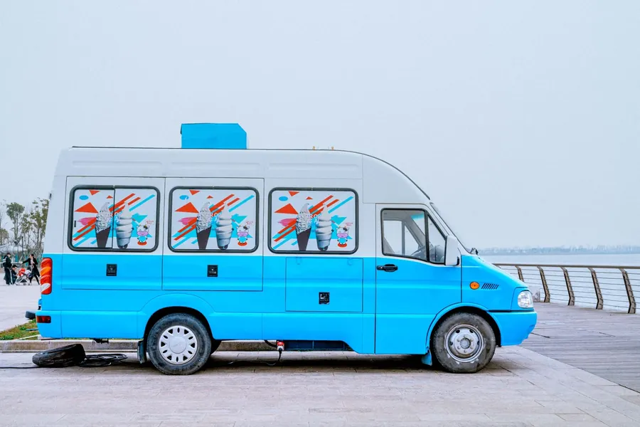A bright blue van with printed graphics along the side