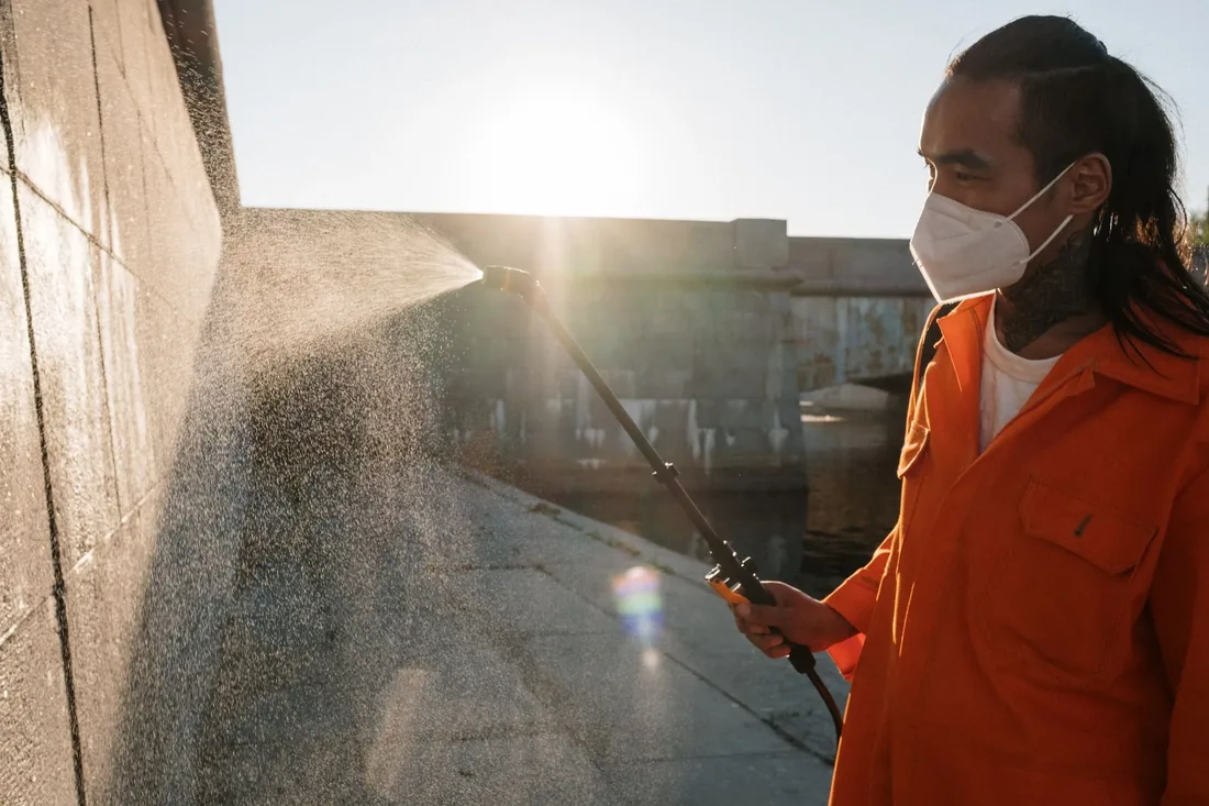 A technician treating along an outside wall