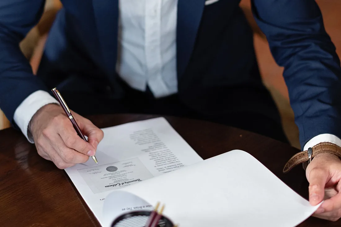 Two people signing paperwork at a desk