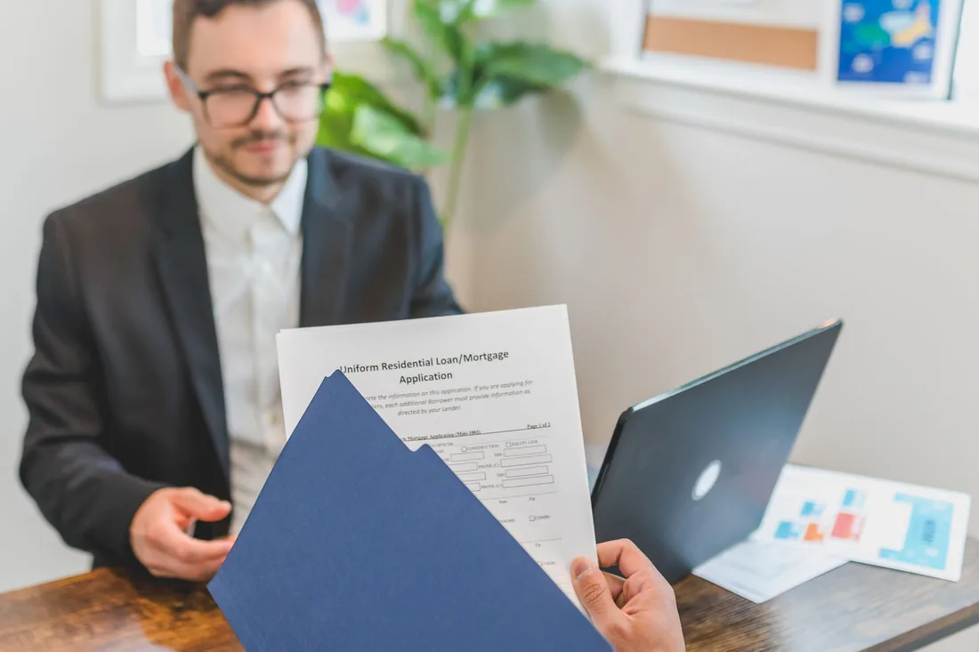A signer with a document folder and a laptop
