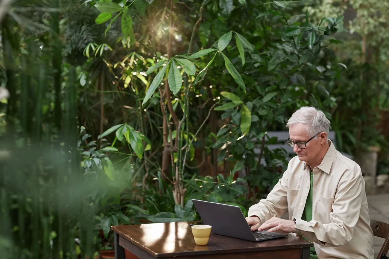 A man working at a laptop in a green garden office