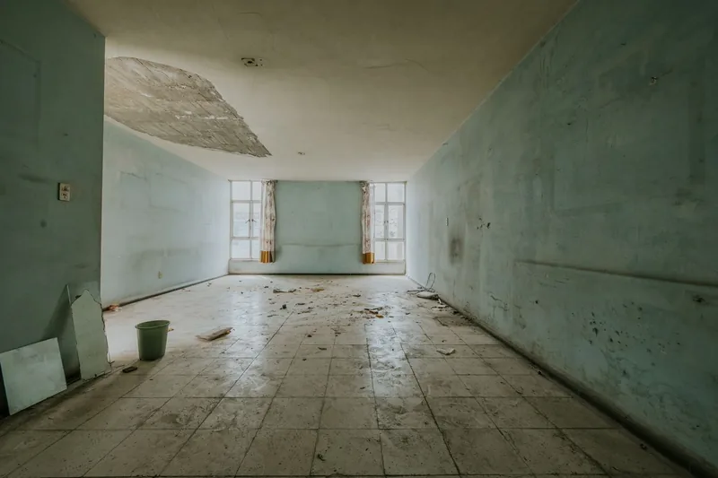 A water damaged corridor with peeling walls