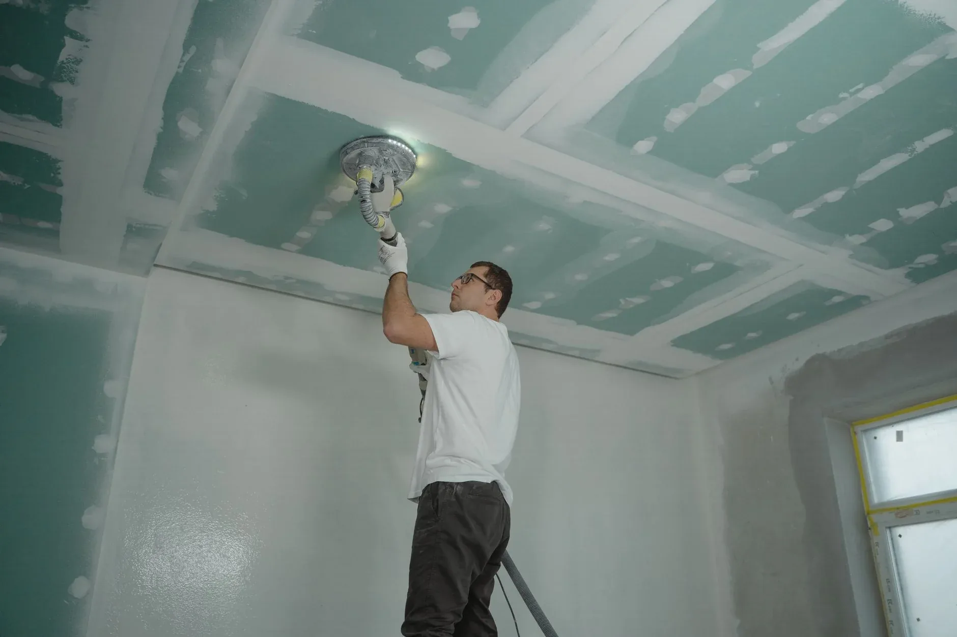 A technician repairing a ceiling after water damage