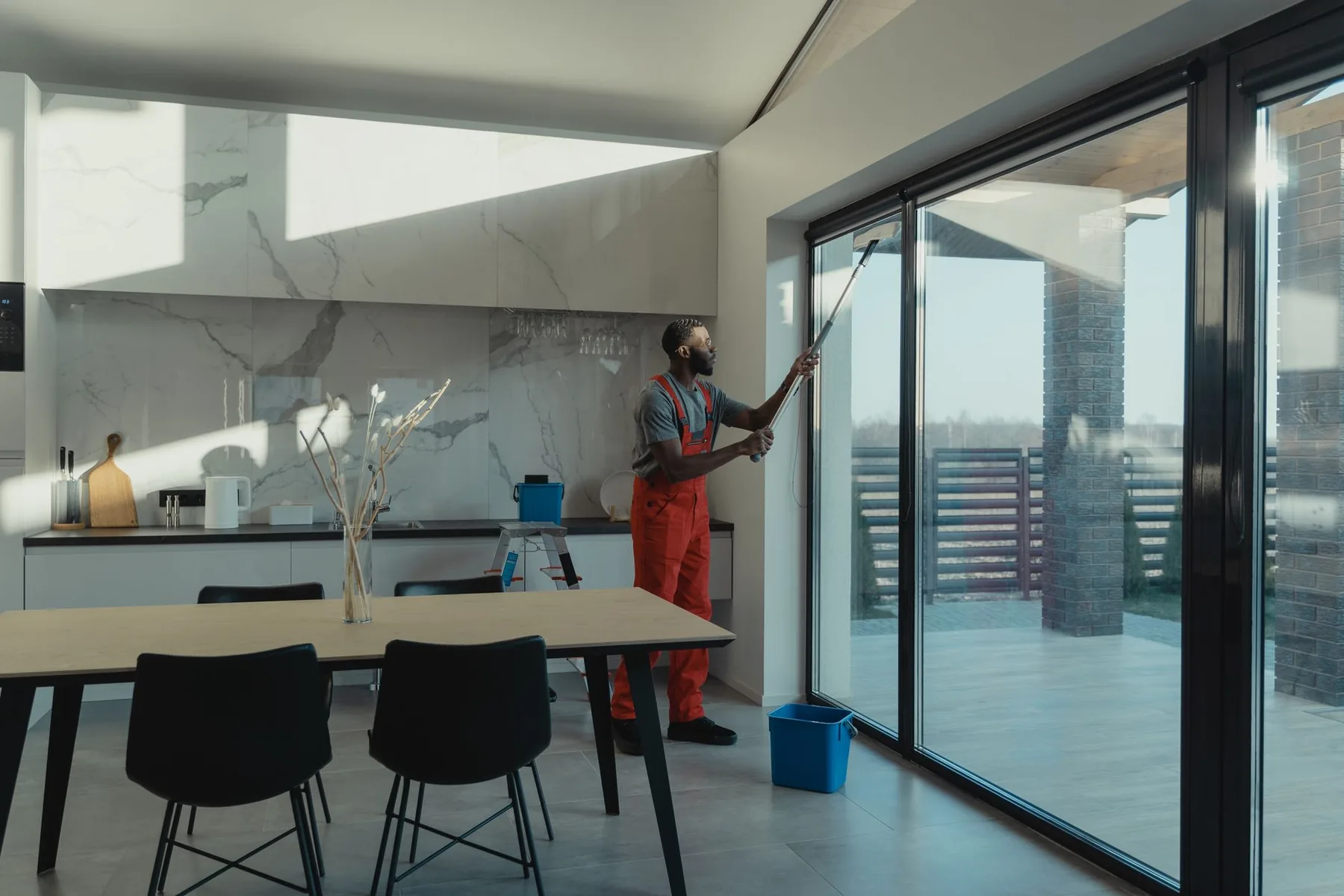 Window cleaner working a pole across full height glass