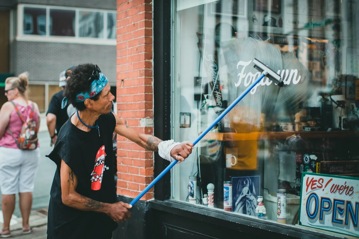 Shopfront glass being cleaned with a pole