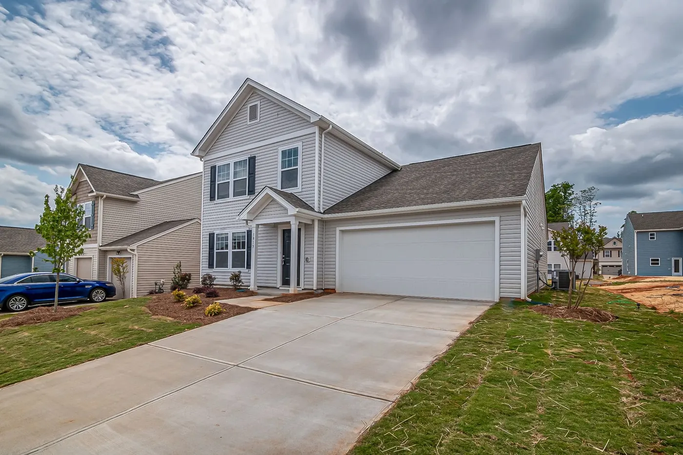A two story house with a long driveway and a garage