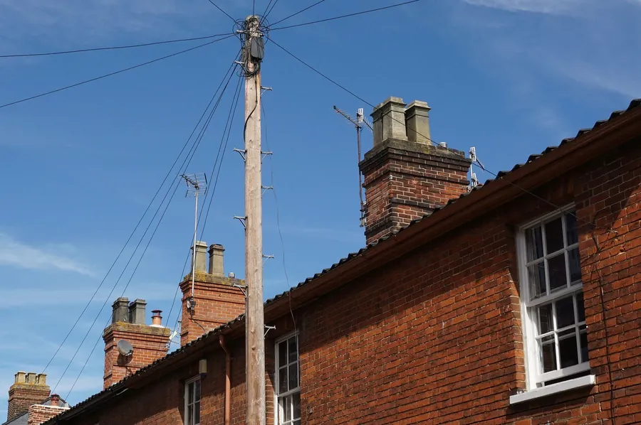A row of red brick terraced houses with chimneys