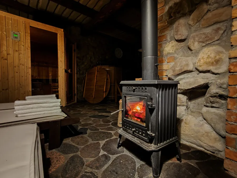 A cast iron stove against a stone wall