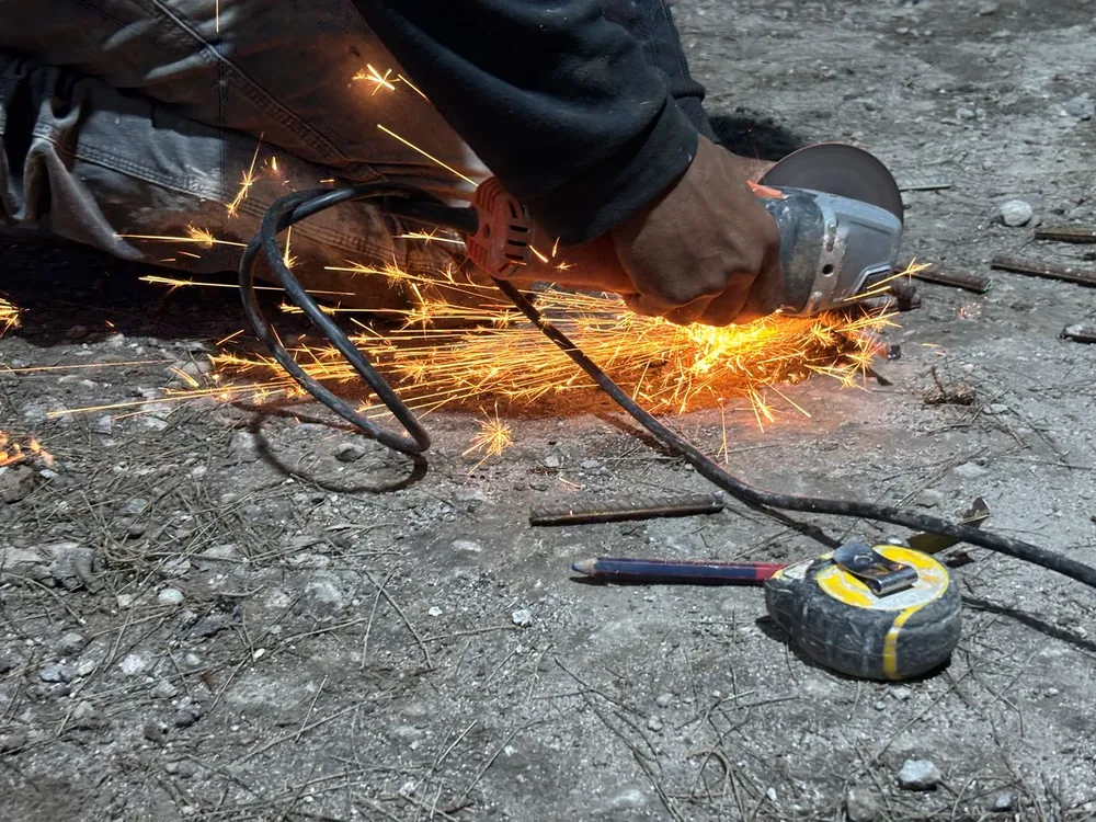 An angle grinder throwing sparks across a concrete floor