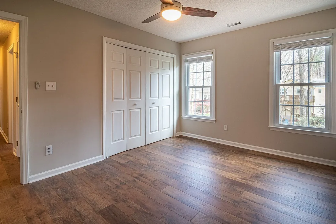 A finished bedroom with a new dark wood floor
