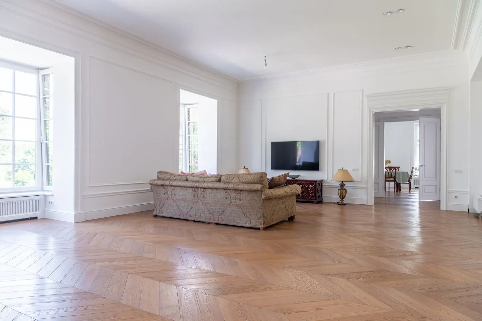 A formal front room with an oak herringbone floor