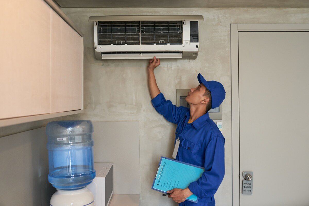 Technician checking a wall-mounted air conditioner
