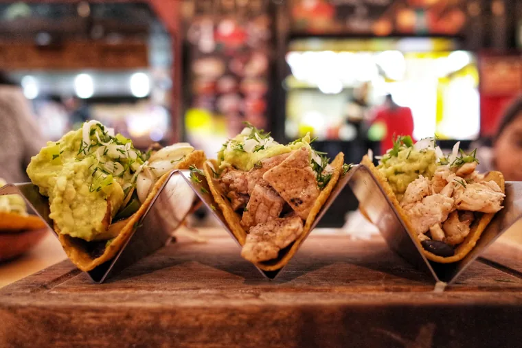 Three tacos lined up on a board