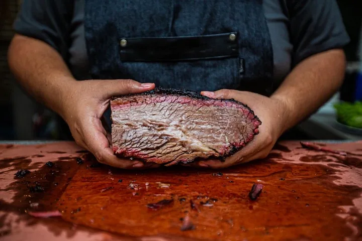 A whole oak-smoked brisket on a board