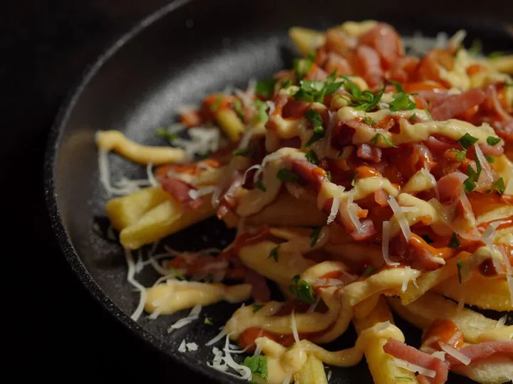 A pan of loaded fries with bacon and cheese