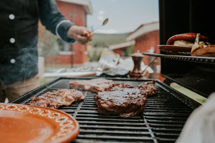 Steaks and sausage over open flame