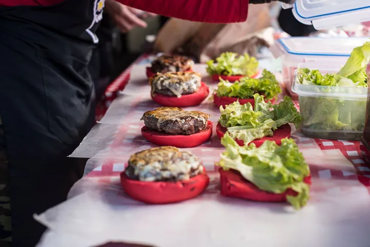 A row of double smash burgers on trays