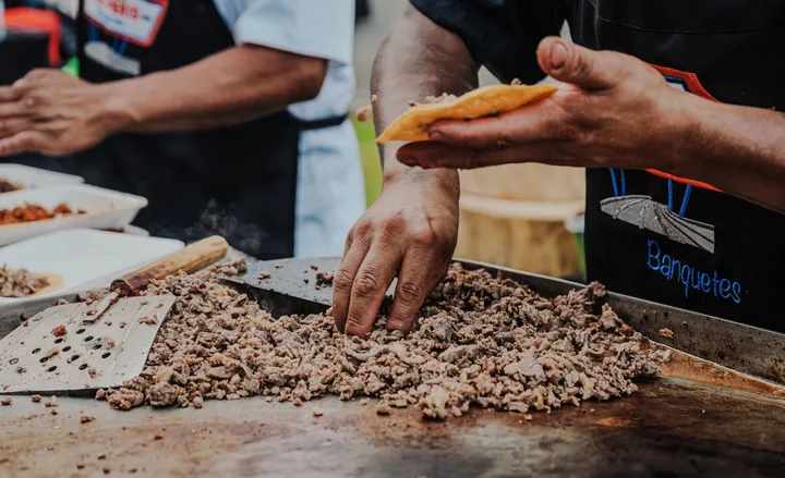 Carne asada taco being folded over the griddle