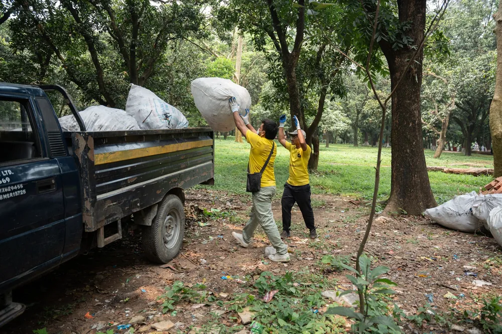 A crew loading bags of waste into the truck