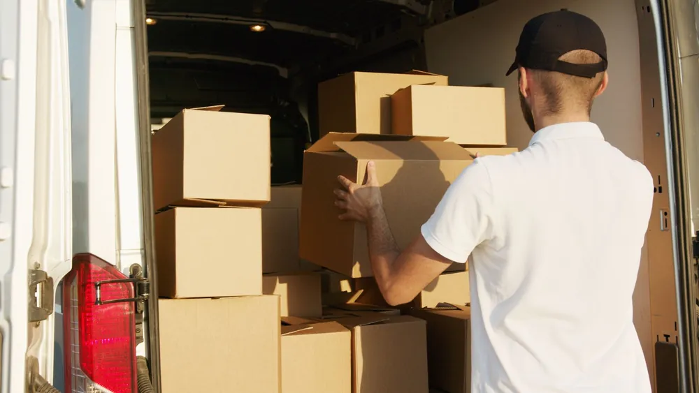A crew member loading boxes into the van