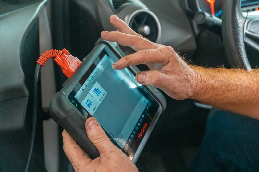 A diagnostic tablet plugged into a car