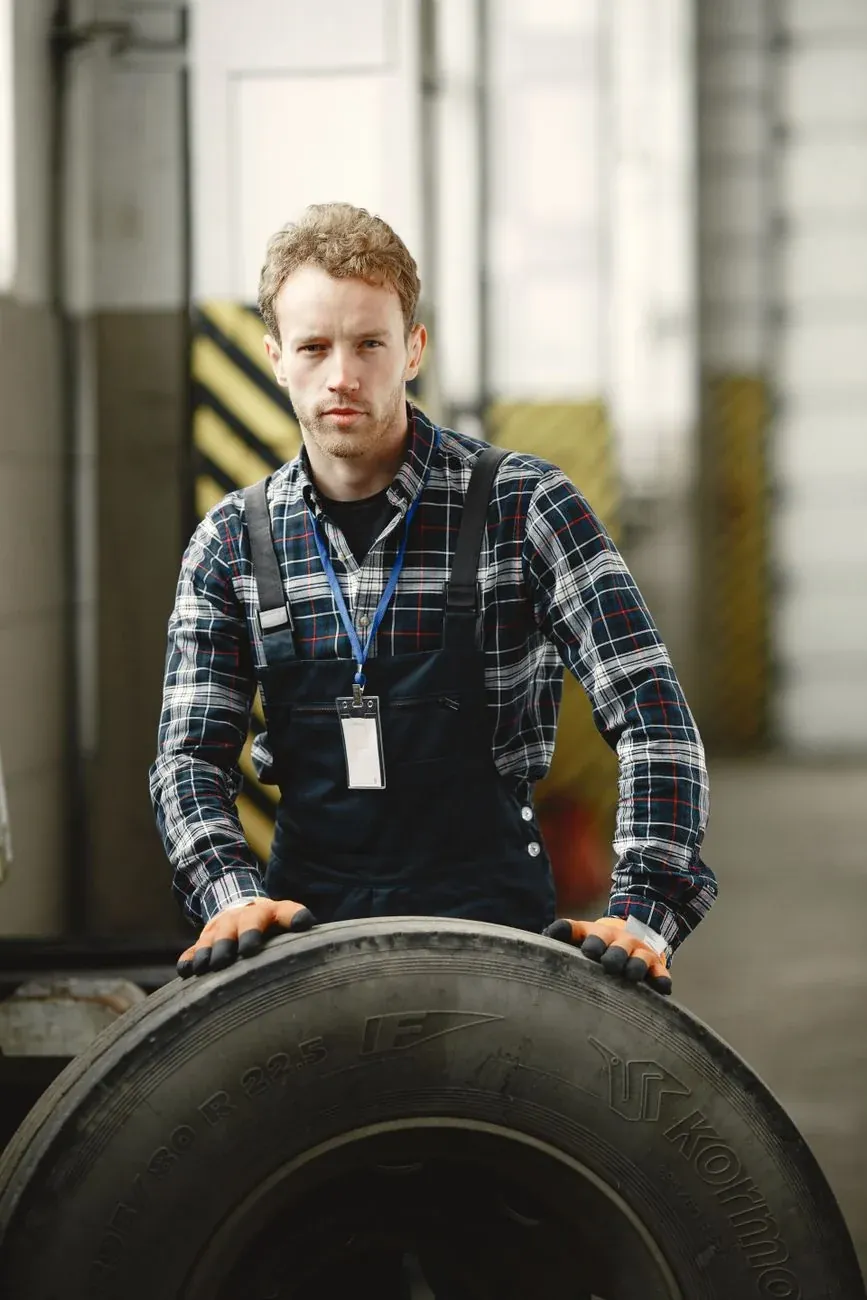 Sam Price with a tyre on the workshop floor