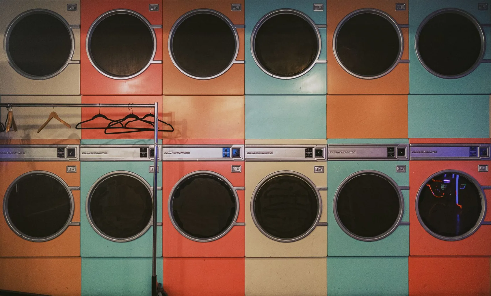 A row of washers in a bright laundromat