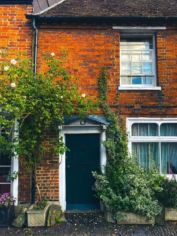 A dark green door in an old brick cottage