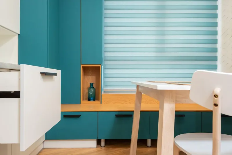 Blue day and night blinds in a kitchen with a white chair