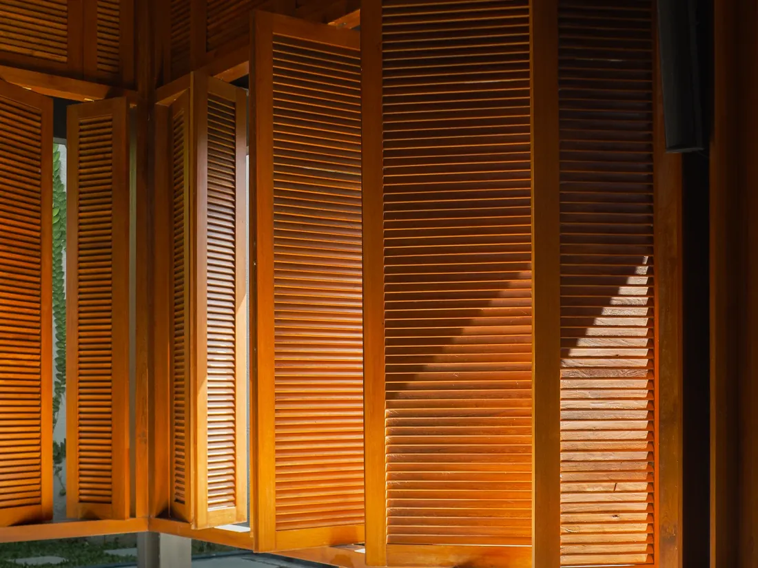 Warm light through wooden louvred shutters
