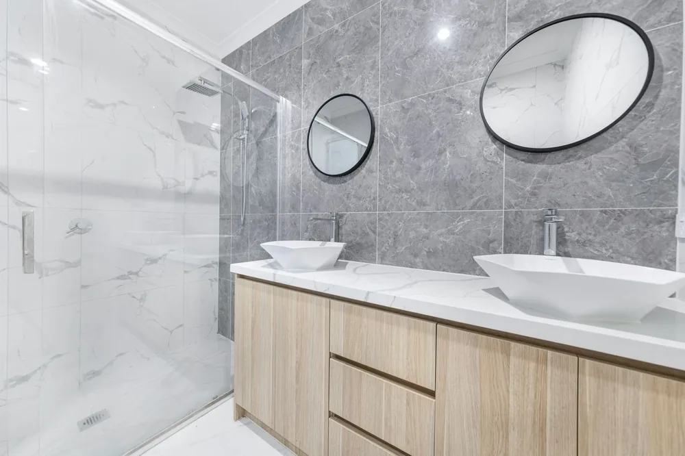 A marble en suite with twin basins and round mirrors