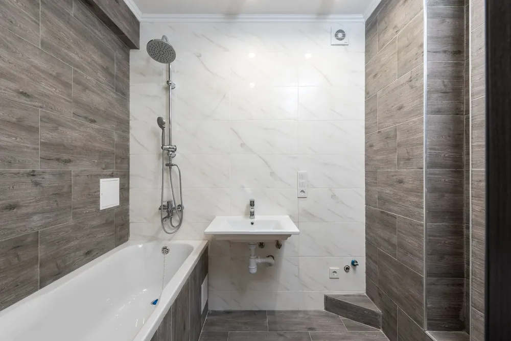 A marble effect family bathroom with bath and shower