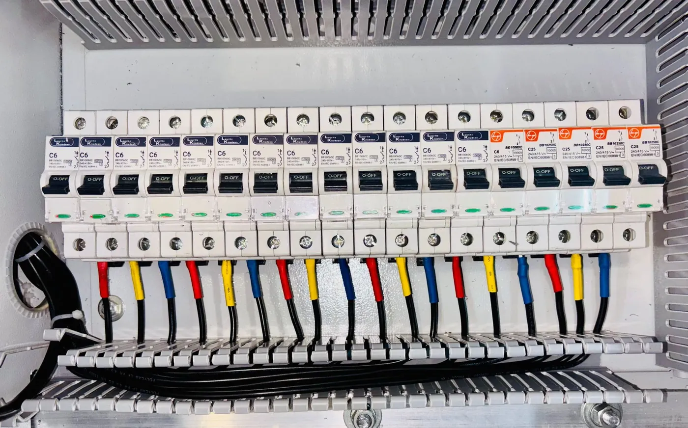 A new consumer unit with a full row of breakers and colour coded cables