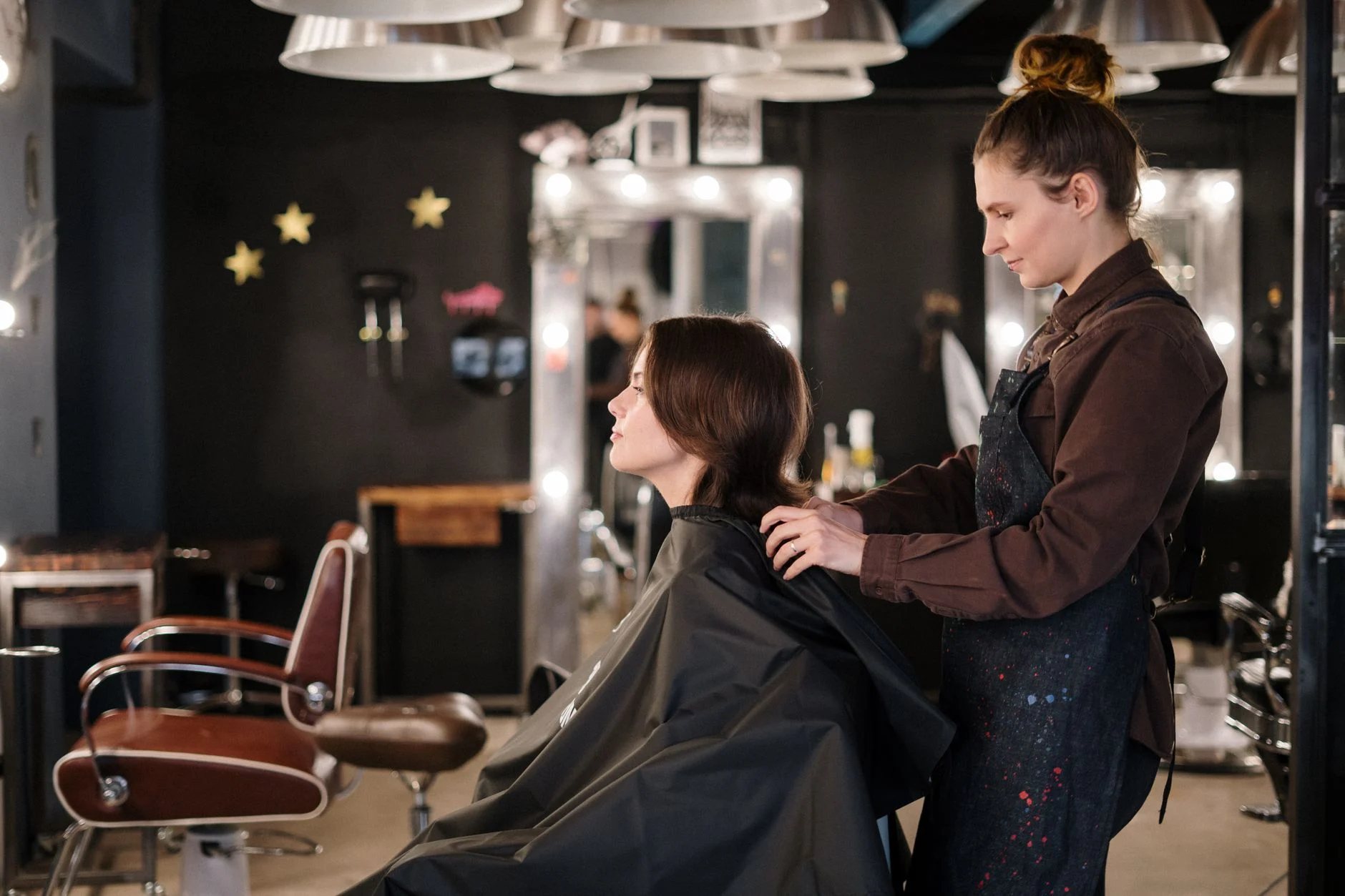 A stylist working in a dark, modern salon