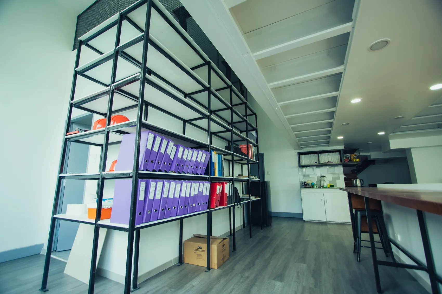A modern office break room with seating and shelving