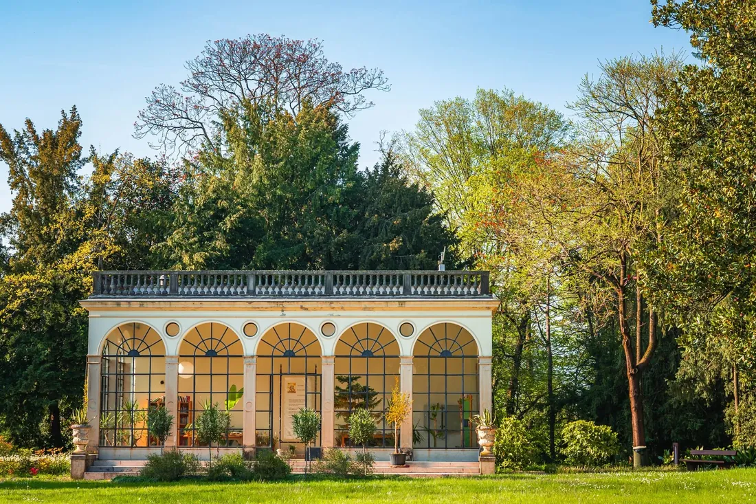 An orangery with arched windows and a parapet roof