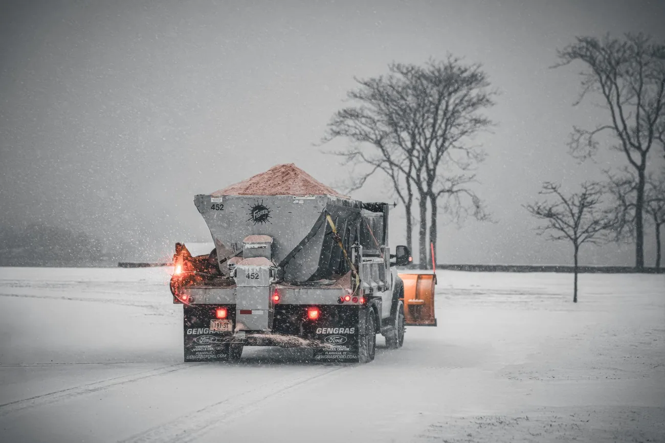 A spreader truck laying salt on a winter road