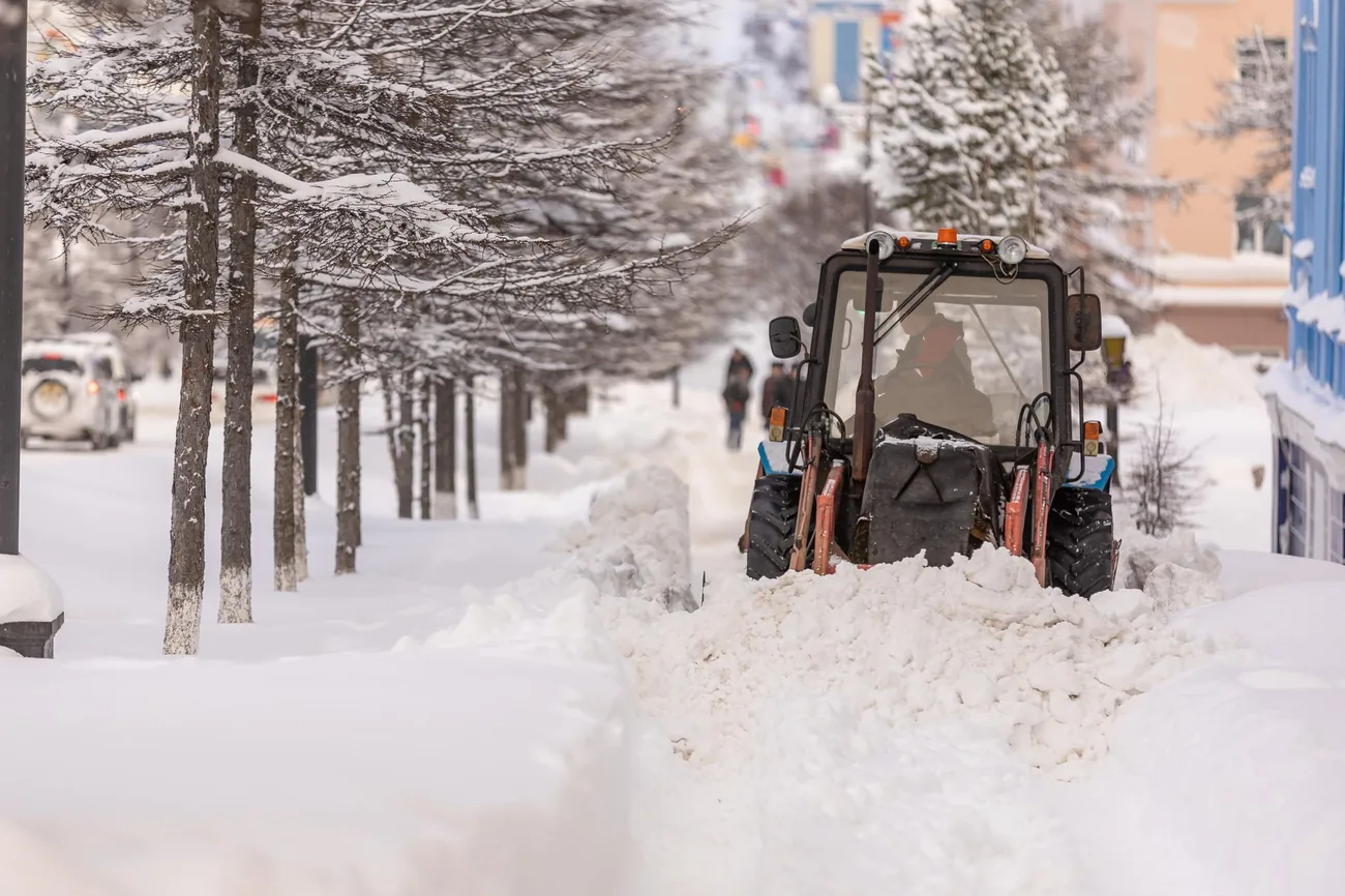A loader clearing deep snow from a street