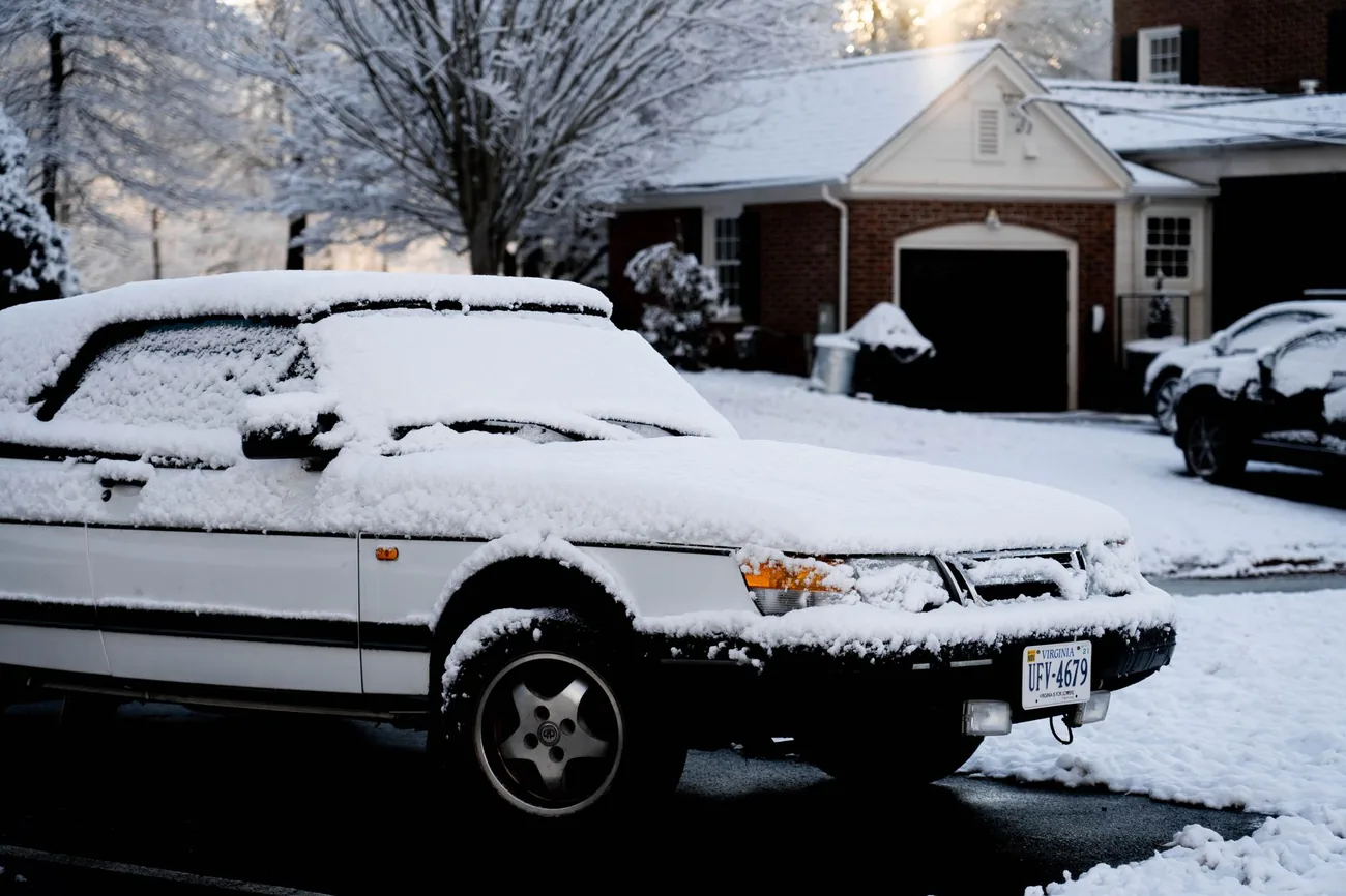 A car buried in snow on a residential street
