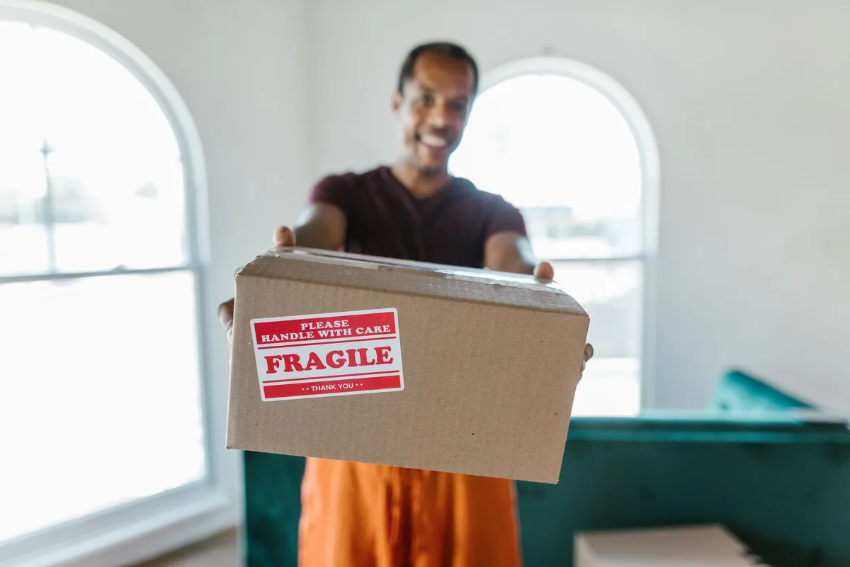 A mover holding a box marked fragile