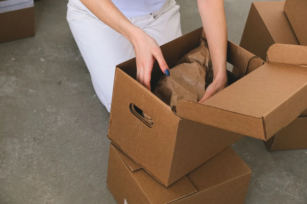 Hands packing a small box