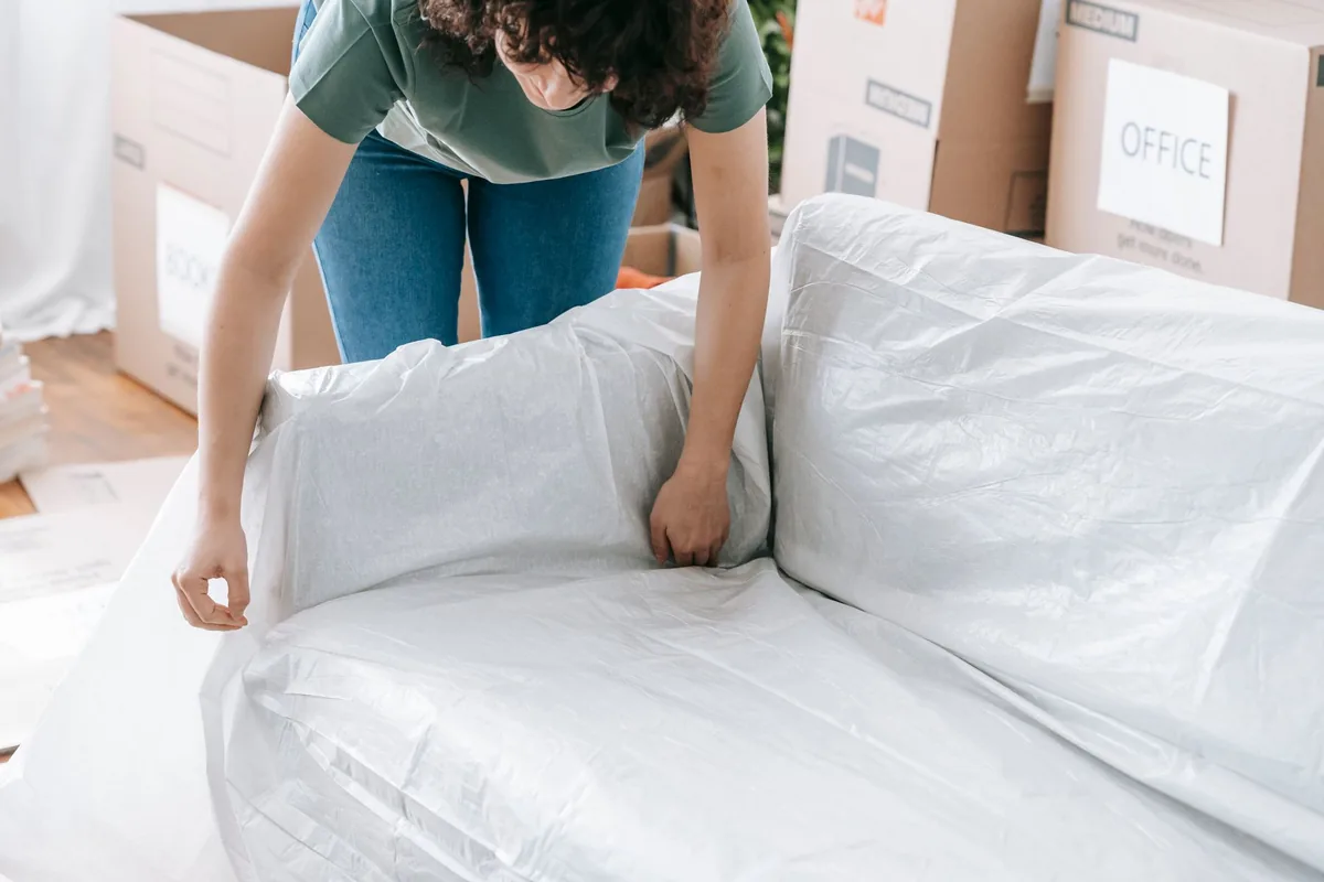 A sofa being wrapped in protective film